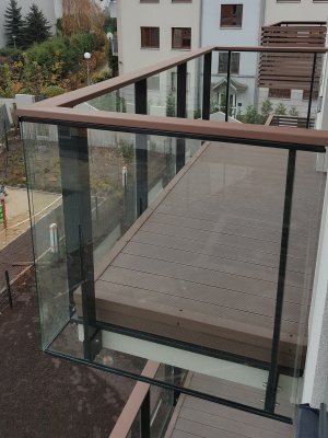 B/018 Balustrady szklane. Balustrada balkonowa szklana, słupki wykonane ze stali profil 100x30, wypełnienie szkło bezbarwne 4.2.4, pochwyt deska kompozytowa